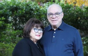 a wife and husband stand smiling