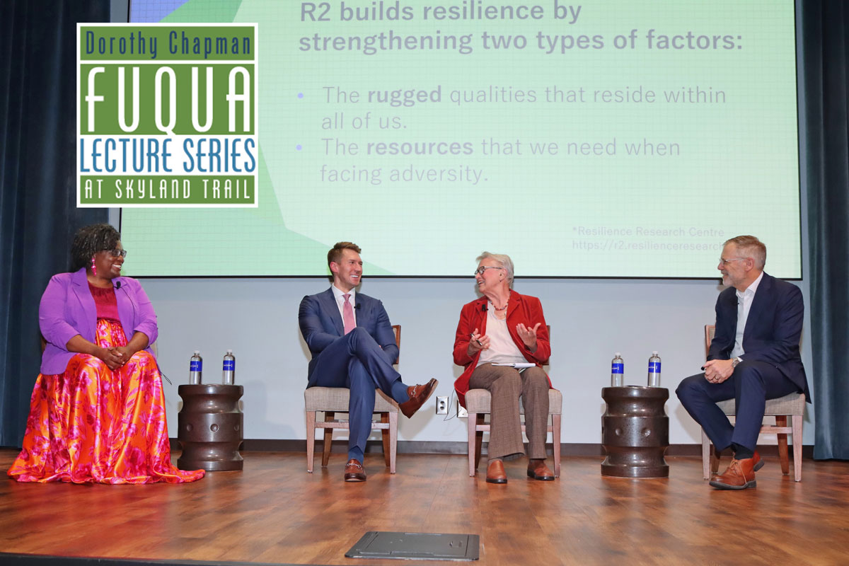 Four adult expert panelists sit on stage for Q&A