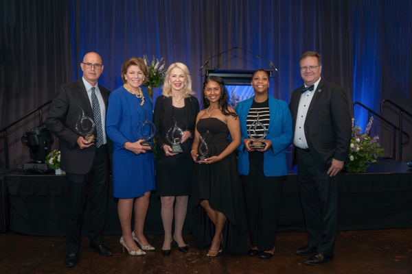 6 individuals standing holding awards