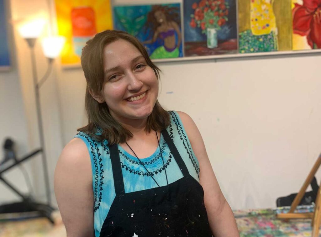 young woman smiling in art studio