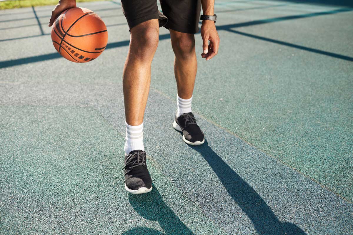 young man playing basketall, shown from waist down