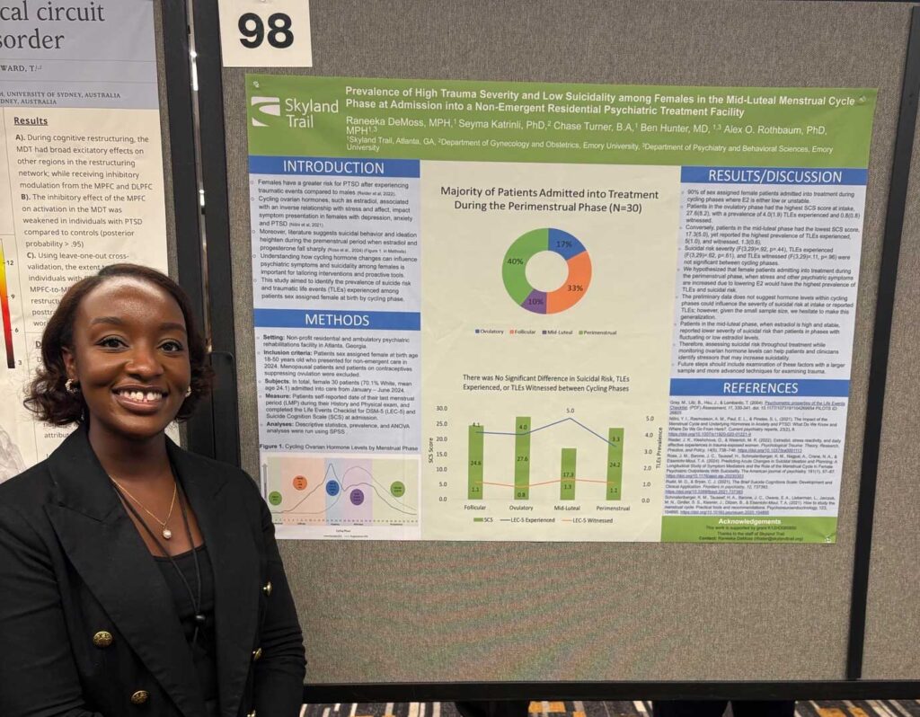 Young woman stands in front of research poster