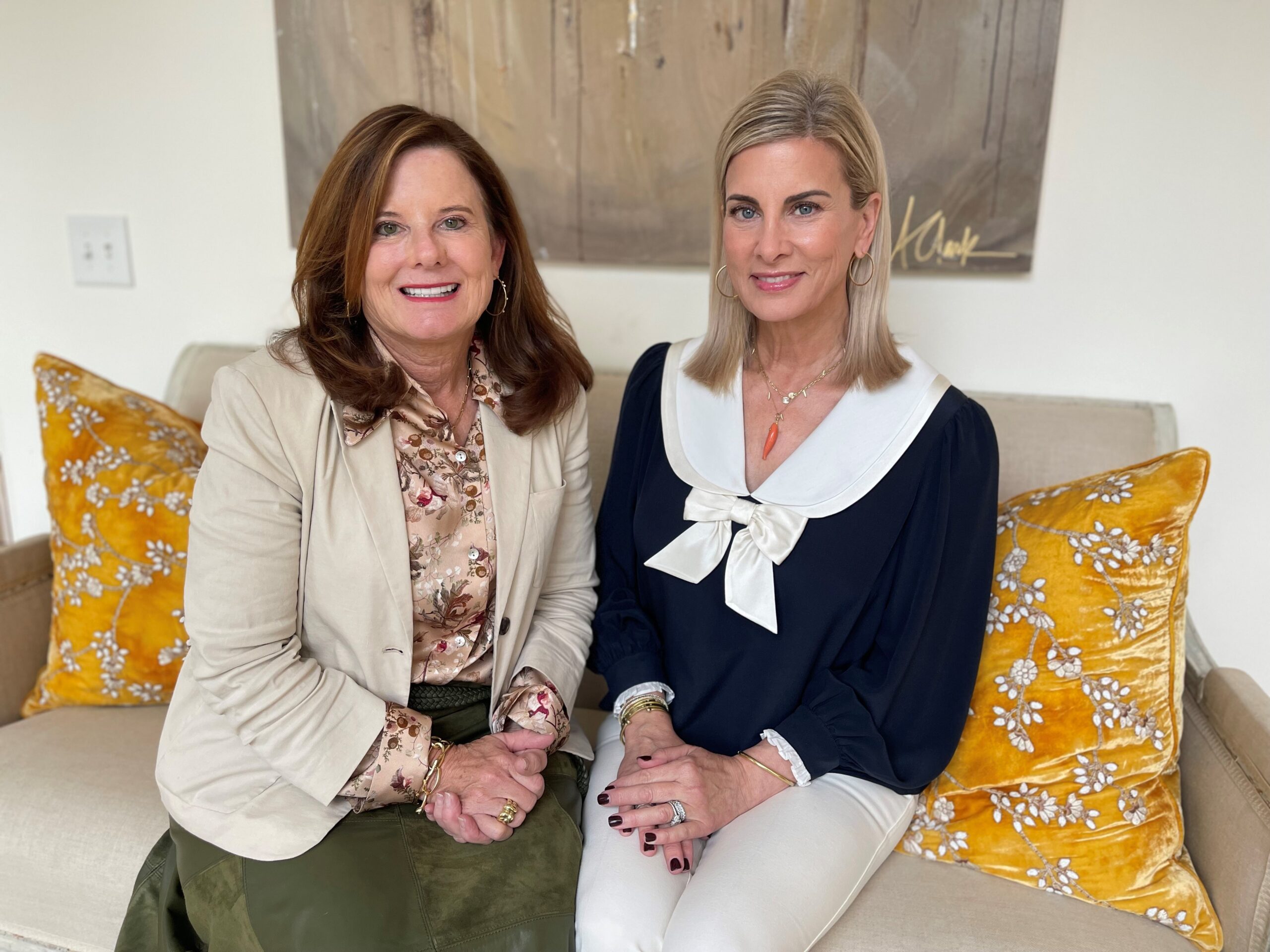 two women seated and smiling