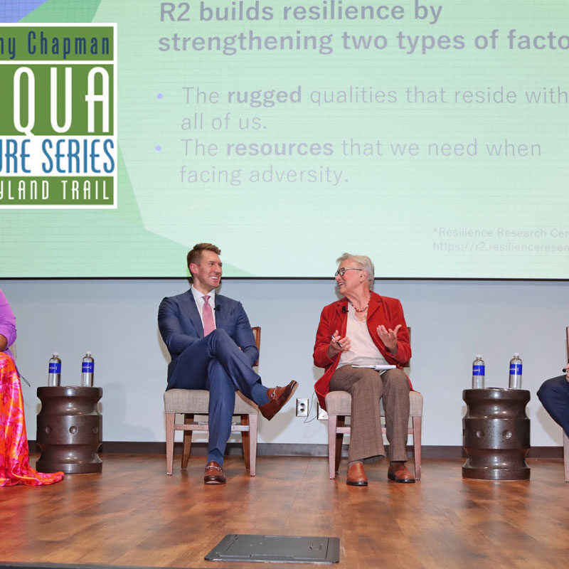 Four adult expert panelists sit on stage for Q&A