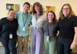 group of five smiling adults standing in a group therapy room at a mental health treatment facility