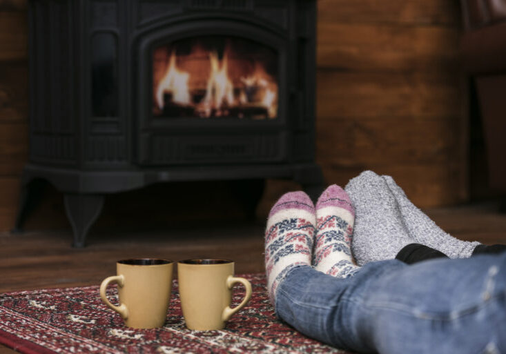 couple warming feet by fireplace