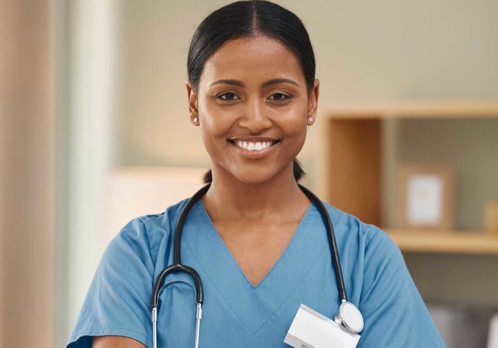 A portrait of a female nurse in a bright, warmly lit room