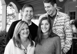 a black and white photo of a smiling family